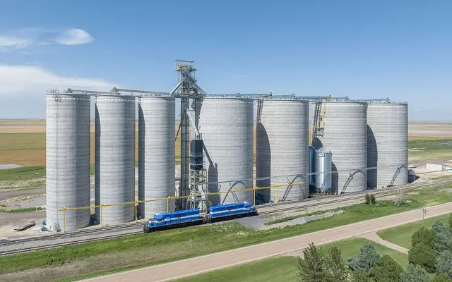Concrete grain-elevator silos beside a rail line